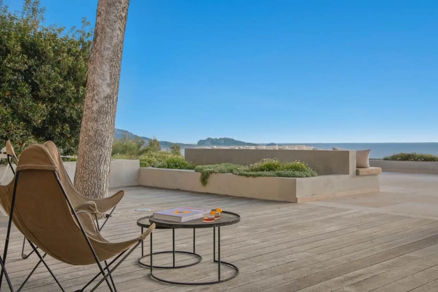 Terrasse en bois, fauteuil et mer en arrière-plan